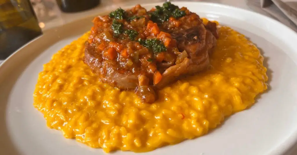 Ossobuco with risotto Milanese: braised veal shank with saffron risotto. This is one of the few Italian dishes where the main course is served together with a first course.