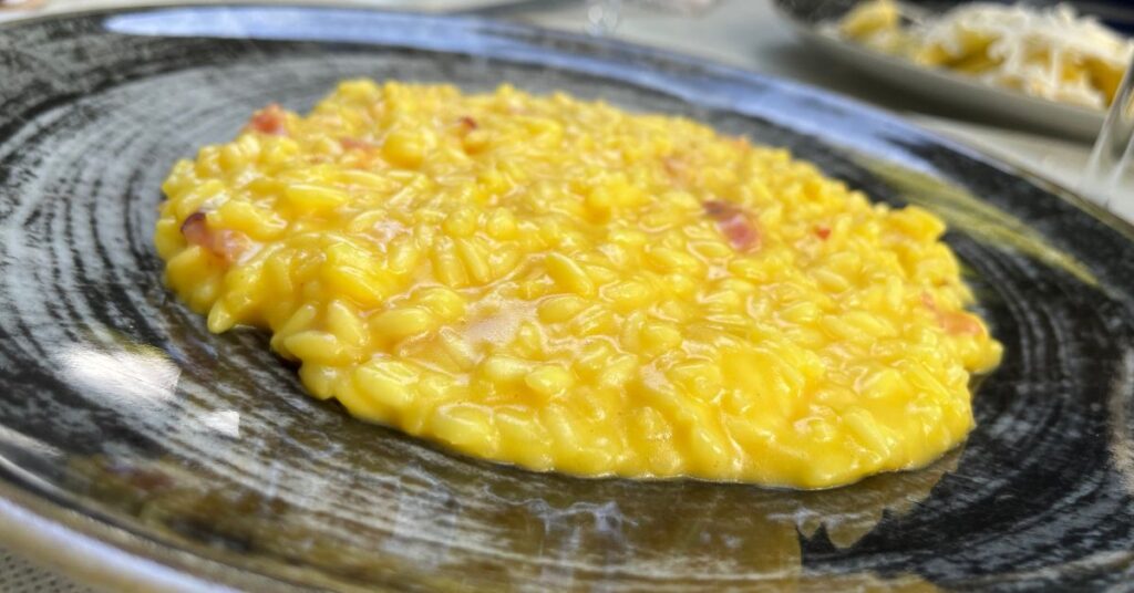 A creamy saffron risotto with pieces of culatello ham.