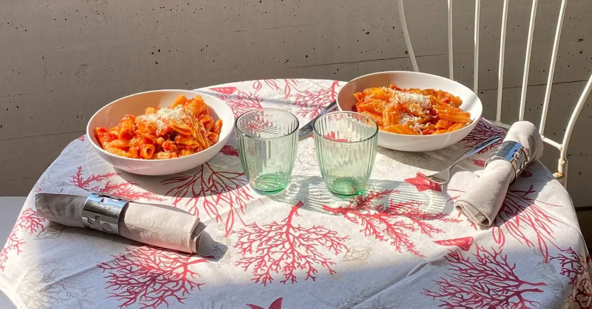 Two portion of pasta on a table.