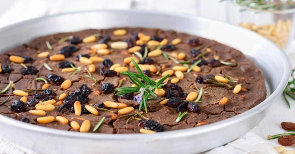 This cake called "castagnaccio" is low and dry looking, brown in color and filled with toasted pine nuts and some rosemary leaves.