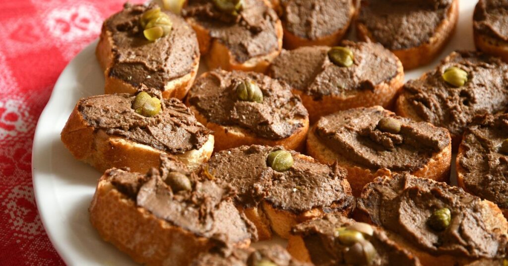 A plate full of crostini with spleen paté, also known as crostini neri.