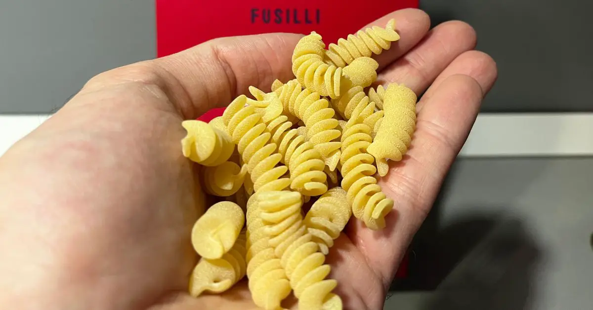 A hand full of fusilli pasta.