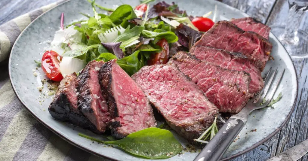 Tagliata di manzo a high-quality cut such as sirloin or ribeye, sliced and served with salad.