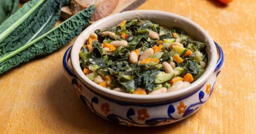 A plate of zuppa pisana, cook with stale bread, kale or Swiss chard, cannellini beans, and vegetables.