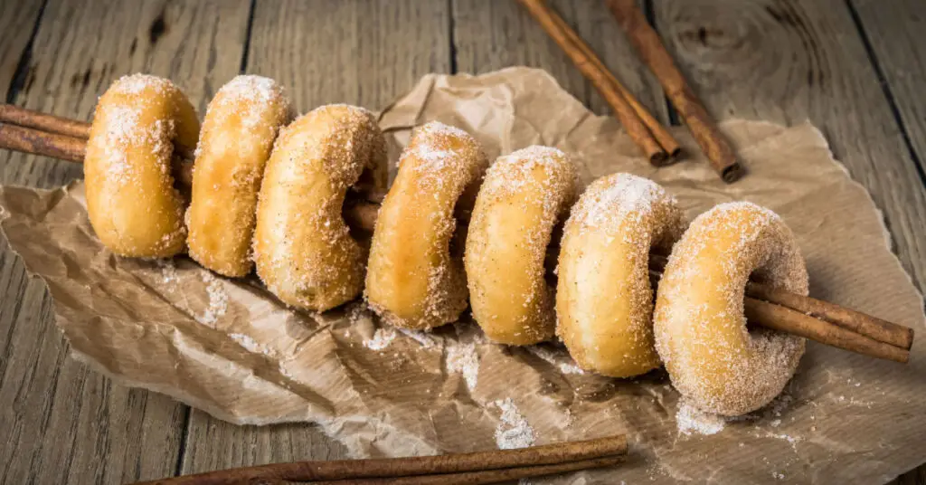 Small golden fried donuts covered in sugar.