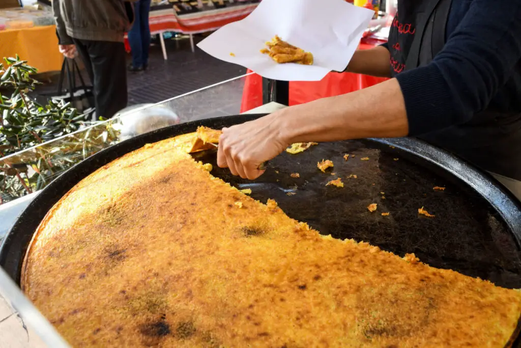 A large round plate where a Cecina was cooked, a flatbread made with chickpea flour, seasoned with oil and rosemary.