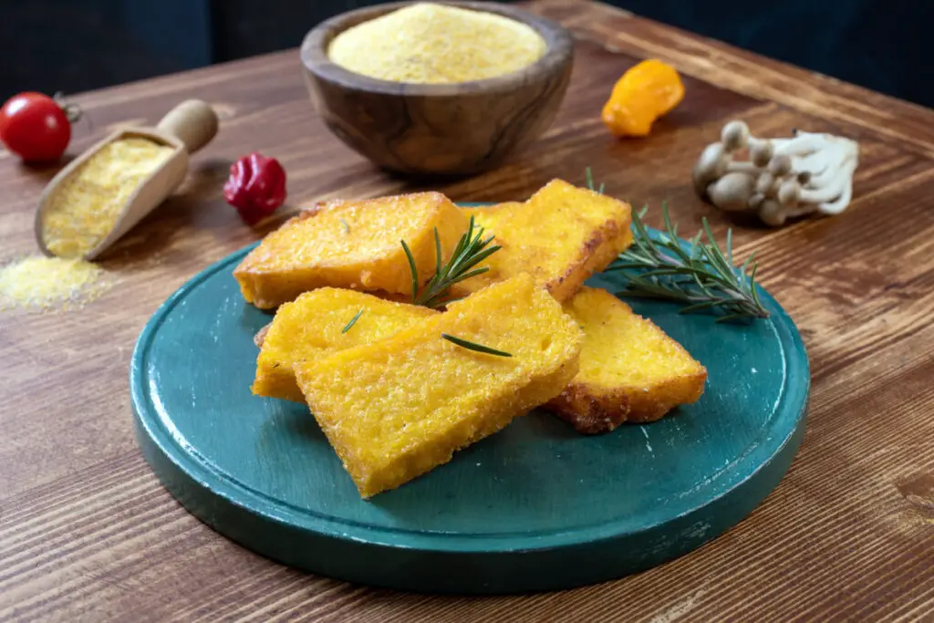 Italian polenta from Tuscany, cut into rectangles and fried, with a crunchy and golden appearance, with some rosemary on the top.
