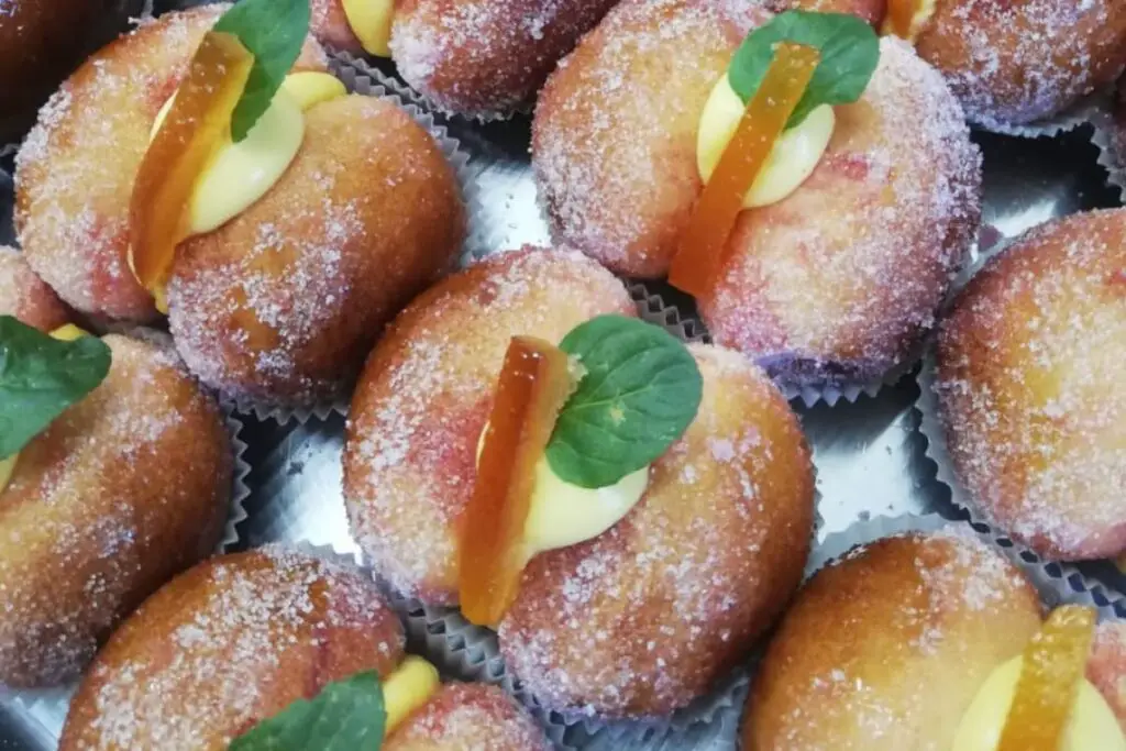 Small peach-shaped pastries, they are made up of two hemispheres of sweet dough covered with granulated sugar and joined by cream on which an ornamental stalk made with candied fruit is placed.