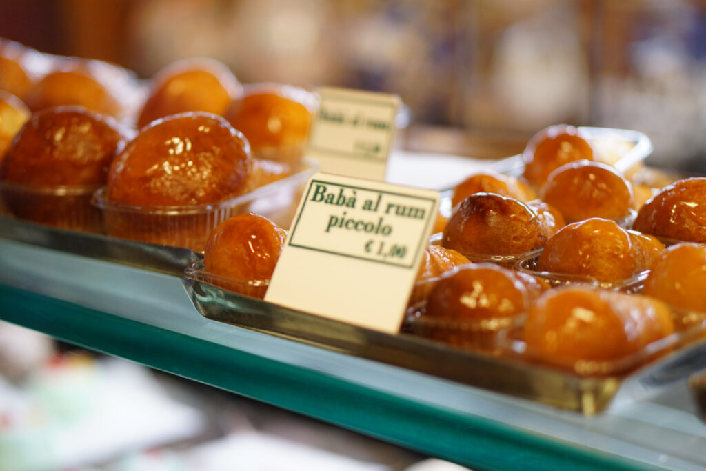 a pastry shop window full of lots of little rum babas, looking round and glazed.