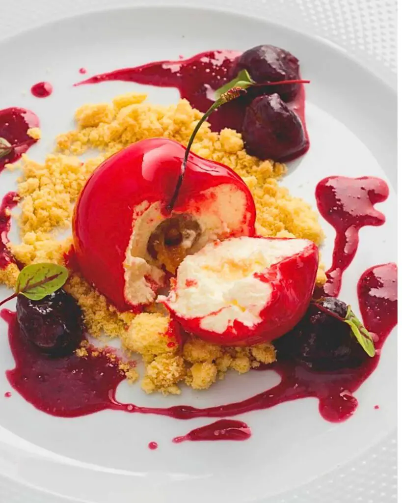 A gourmet dessert plate at L'Insolita Trattoria Tre Soldi, featuring a creatively plated dish with vibrant red elements and delicate garnishes.