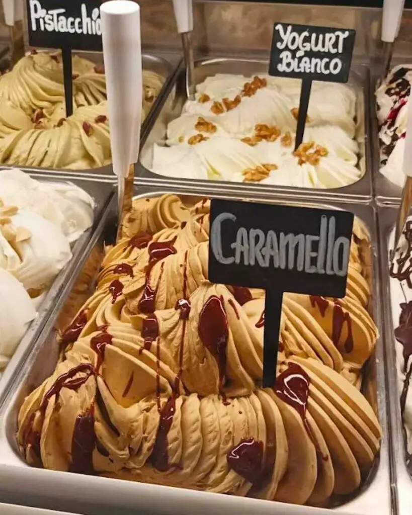 Close-up of caramel, pistachio, and yogurt gelato flavors at Gelateria La Mandorla, showcasing the rich textures and vibrant colors.