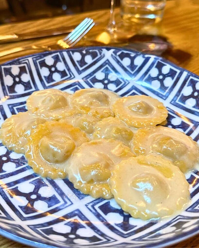 A close-up view of traditional Italian ravioli served at Rezdôra in New York City, showcasing the genuine Emilia-Romagna culinary traditions.