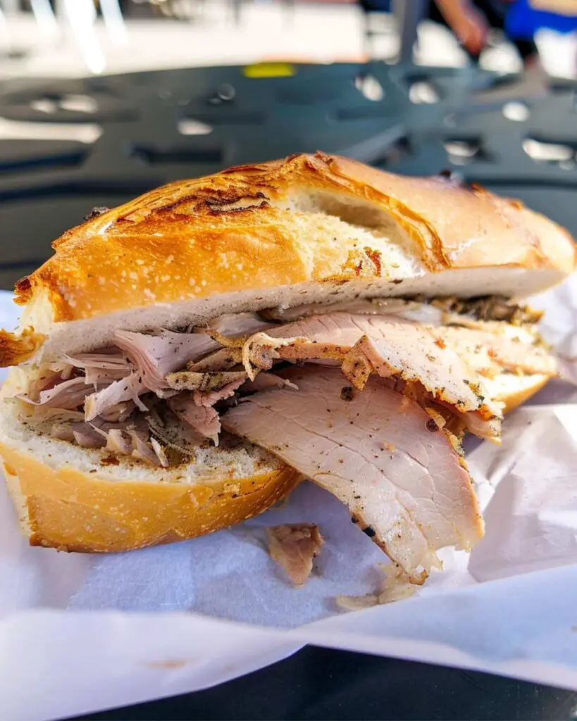 A sandwich filled with porchetta from Er Buchetto, showcasing some of the best street food in Rome.