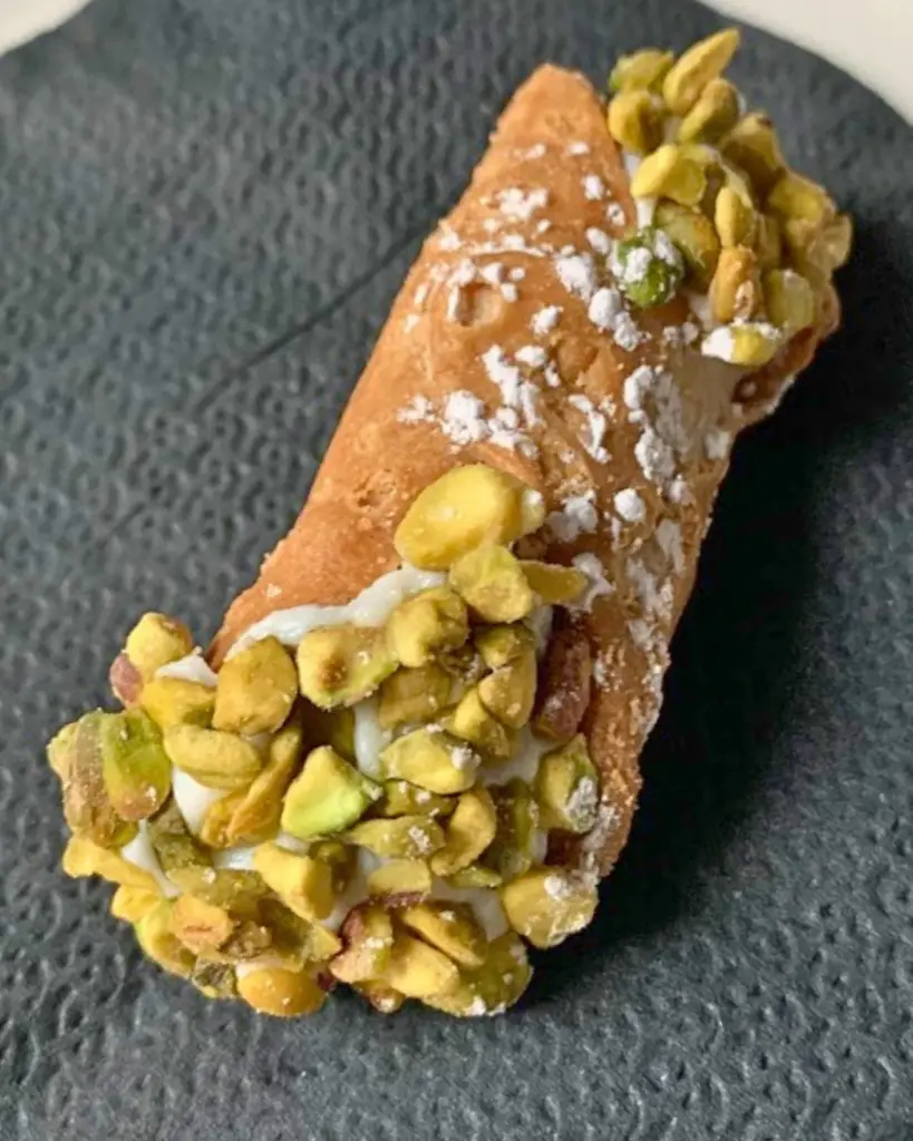 Italian dessert cannoli from Cerasella in Queens, showcasing a pistachio-studded cannoli.