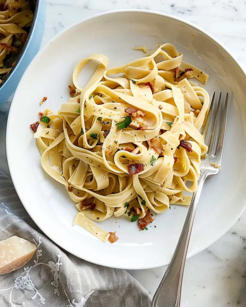 Overhead shot of a creamy gluten free tagliatelle carbonara dish, showcasing the rich and silky carbonara sauce with crispy bits.