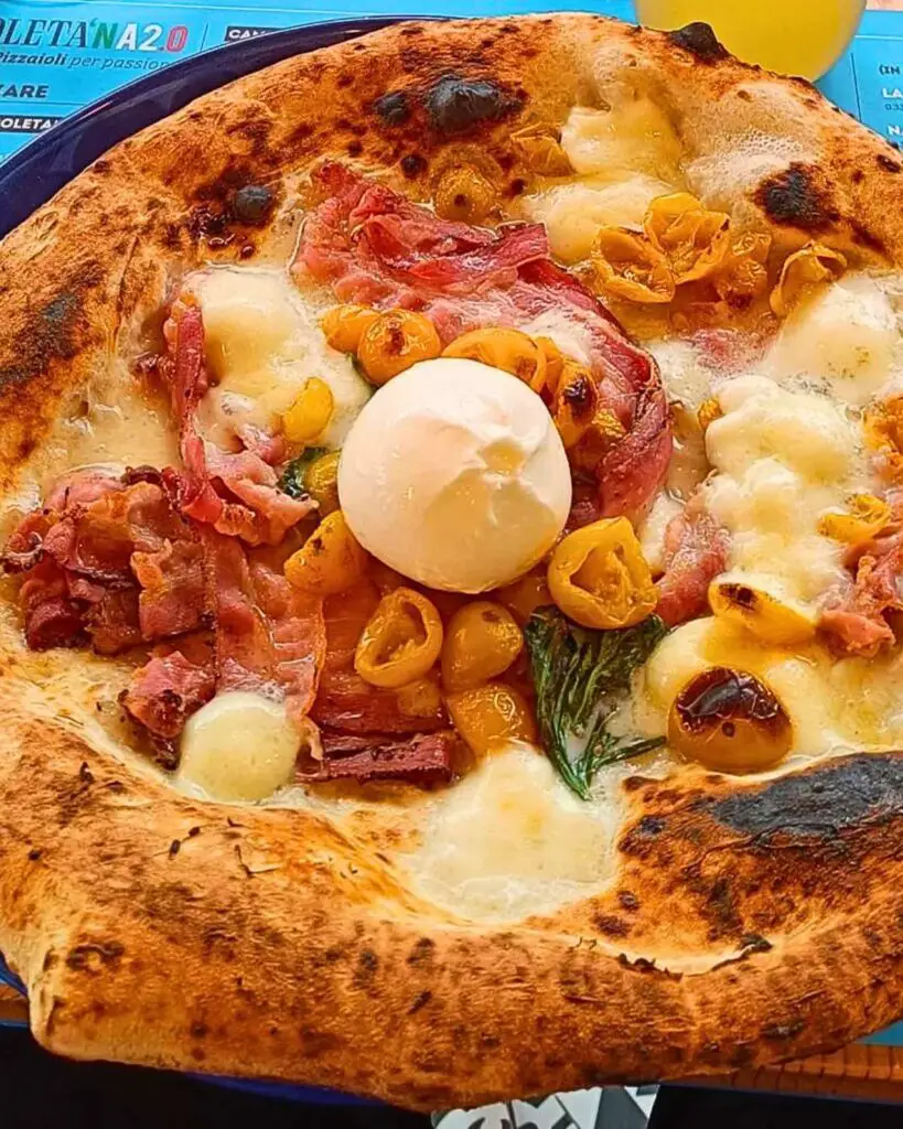 A close-up of a delicious pizza from La Napoletana 2.0 in Siena, featuring a golden crust, fresh toppings, and creamy cheese.