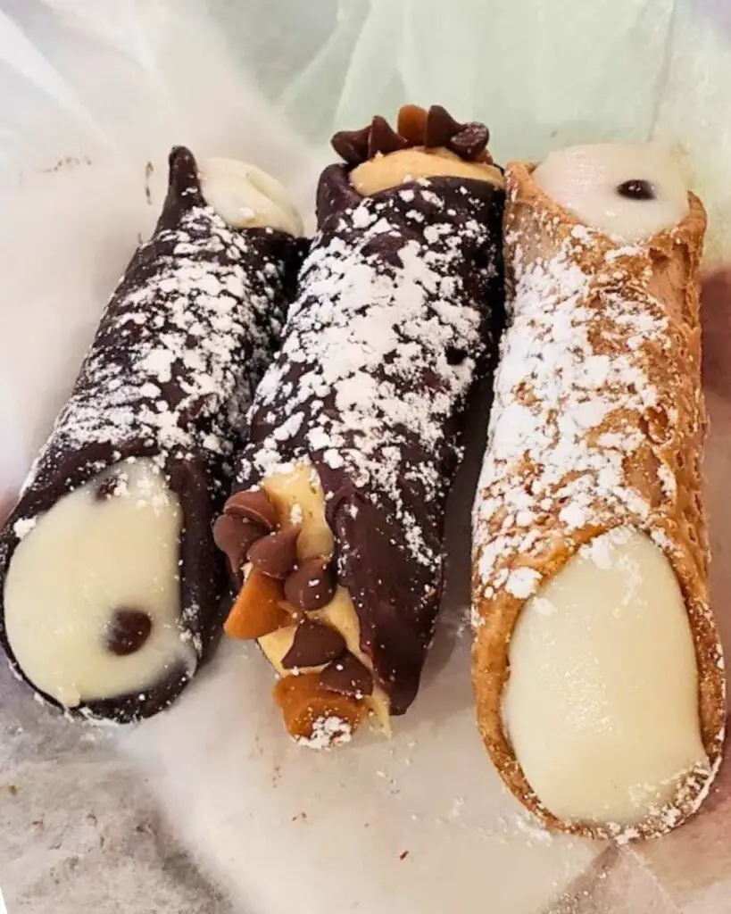 Some of the best Italian cannoli in NYC, filled with creamy ricotta, topped with powdered sugar and chocolate chips.