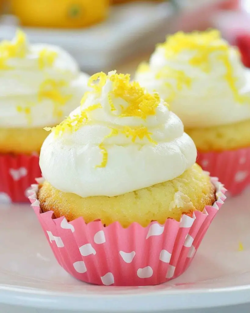 Italian lemon ricotta cupcakes topped with sweet ricotta cream cheese frosting, sprinkled with fresh lemon zest, showcasing an Italian lemon cream cupcakes recipe.