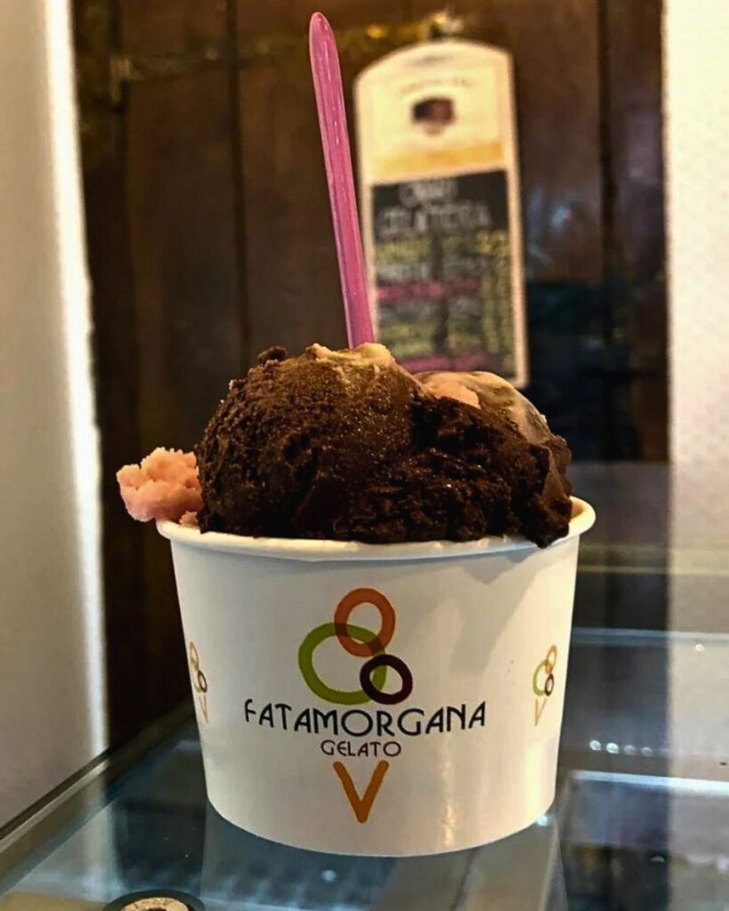 A cup of rich chocolate and fruit-flavored gelato from Fatamorgana in Rome, representing the best gelato in Rome with an inviting and authentic gelato Rome aesthetic.