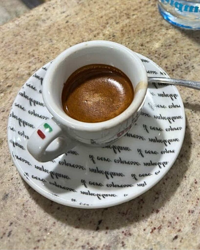 An espresso served in a white cup with a saucer at Bar Nilo, showcasing the neapolitan coffee and Naples coffee aesthetic.