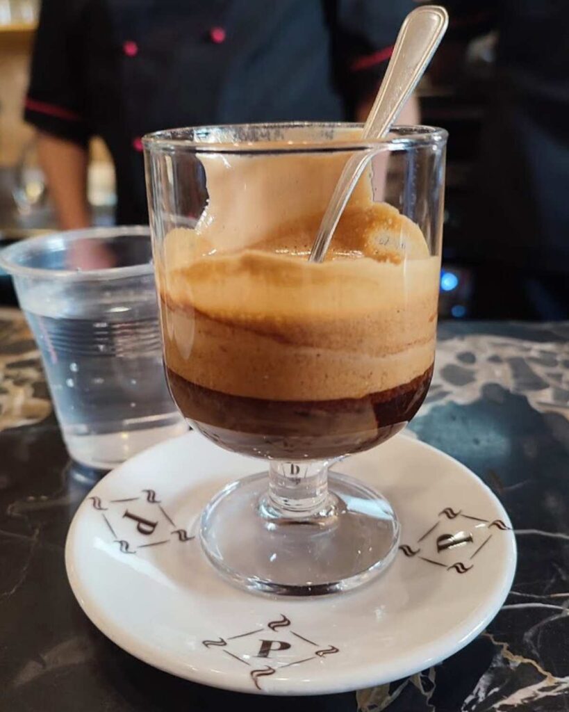 A rich, creamy espresso served in a clear glass at Il vero Bar del Professore, showcasing the unique Naples Italy coffee experience.