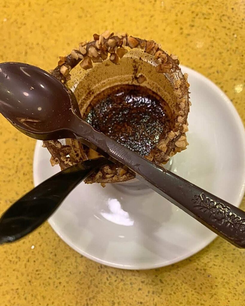 A beautifully decorated coffee cup with nuts and chocolate at Caffè Ciorfito, highlighting the Naples coffee aesthetic and unique cafe experience.