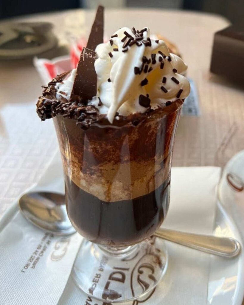  A decadent coffee topped with whipped cream and chocolate at Ceraldi Caffe', highlighting the coffee in Italy and Naples coffee aesthetic.