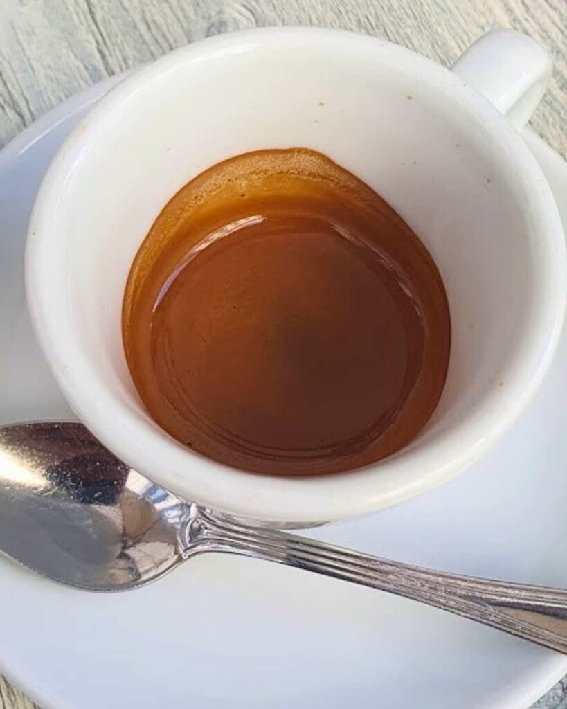 n espresso in a white cup served at Gran Caffè La Caffettiera, highlighting the neapolitan cafe and Naples Italy coffee experience.