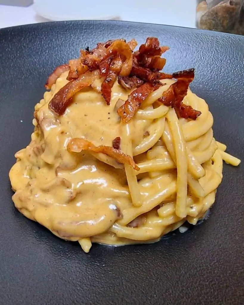 A plate of spaghetti carbonara Rome at La Ciambella Bar à Vin con Cucina, featuring creamy sauce and crispy bacon, showcasing the carbonara Rome aesthetic.