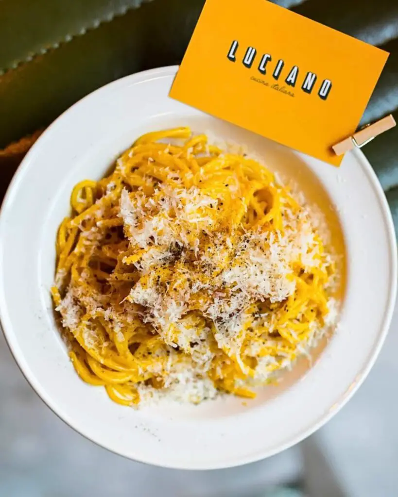 A bowl of carbonara pasta Rome at LUCIANO Cucina Italiana, showcasing creamy pasta with a generous topping of grated cheese, highlighting the best pasta places in Rome.