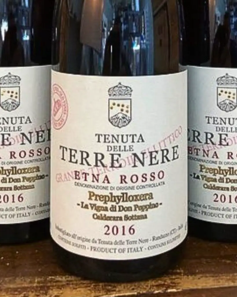 Three bottles of Tenuta delle Terre Nere Etna Rosso 2016, showcasing the elegant Italian wine label, highlighting one of the best Italian wines from the volcanic region of Etna