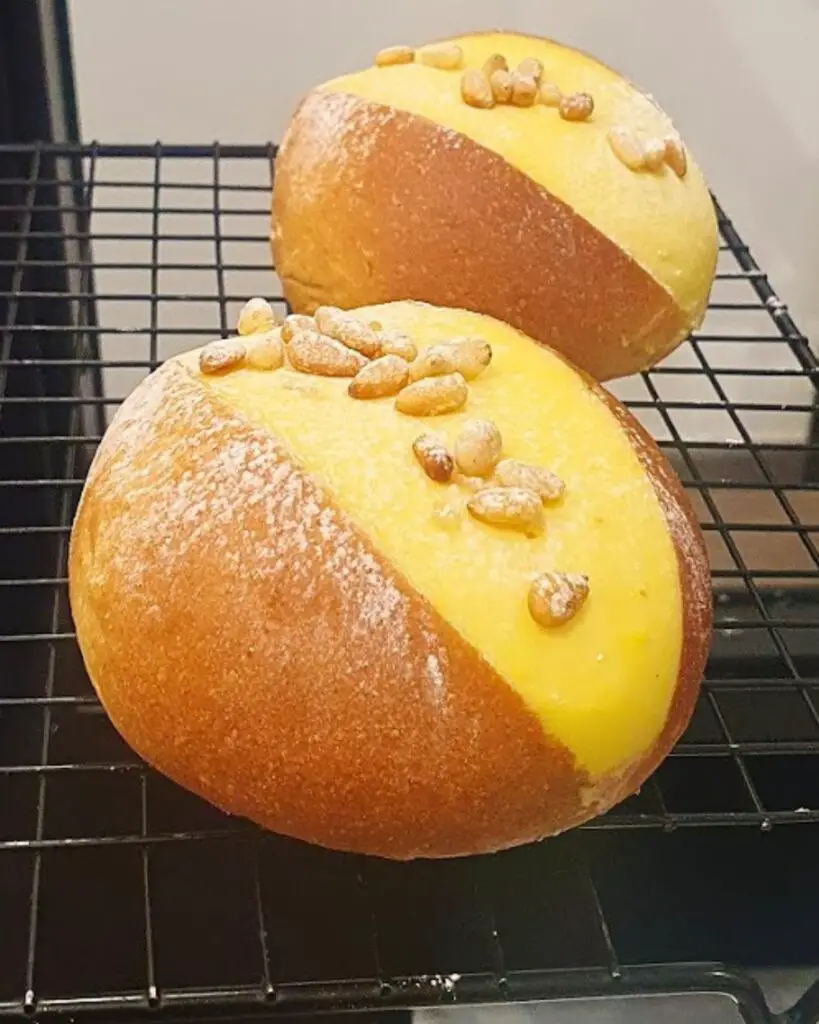 Famous maritozzi from Faro pastry shop in Rome, featuring classic and "torta della nonna" varieties with cream and pine nuts.