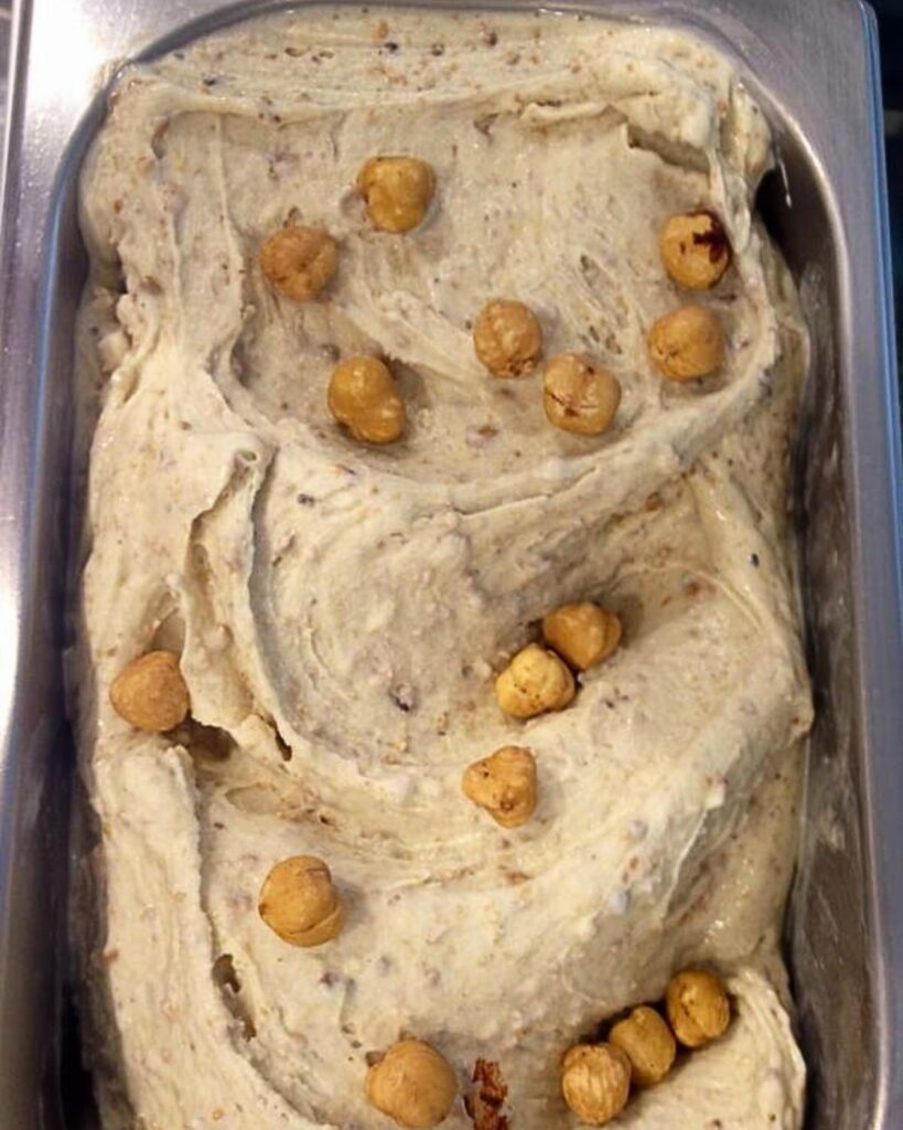 A tray of creamy hazelnut gelato topped with whole hazelnuts at Otaleg! in Rome, representing a delicious option for ice cream in Rome Italy with a rich, authentic gelato Rome aesthetic.