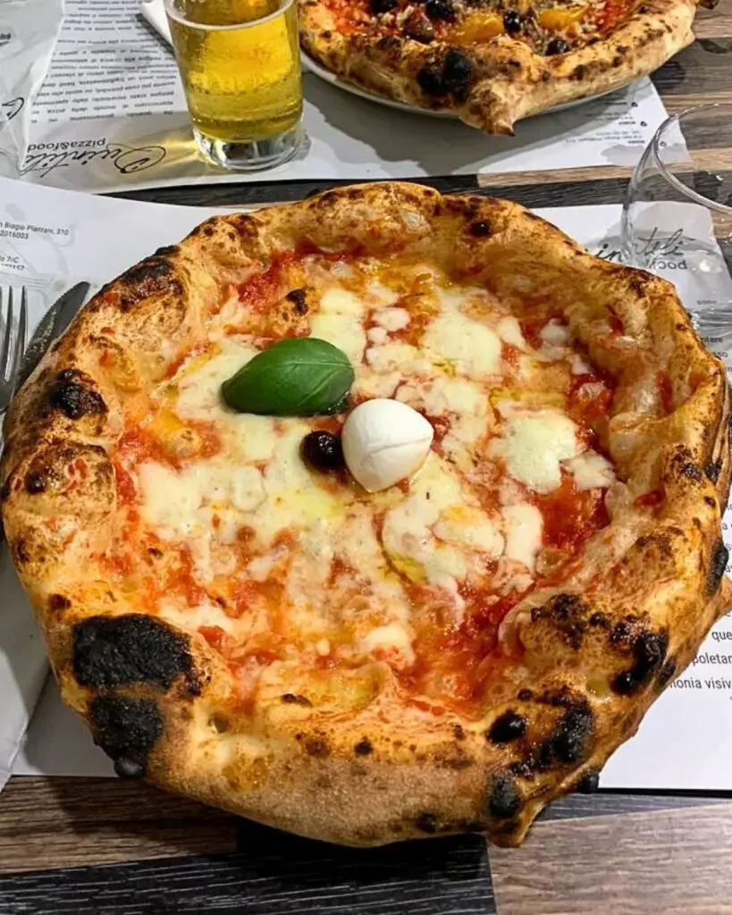 Enjoying a Casertana-style pizza with a pronounced crust at I Quintili, celebrated for crafting some of the best pizzas in Rome.