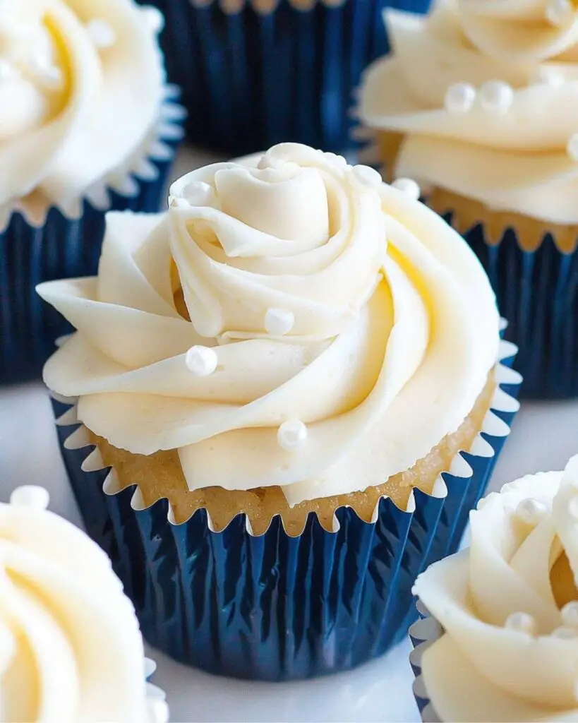 Elegant Italian bridal shower cupcakes decorated with fluffy white buttercream, sugar pearls, and white roses, showcasing Italian themed cupcakes and Italian decorated cupcakes.