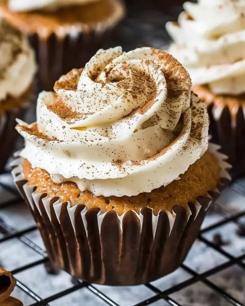 Italian rum cupcakes topped with creamy rum buttercream frosting, dusted with cinnamon, showcasing Italian desserts cupcakes and Italian themed cupcakes.