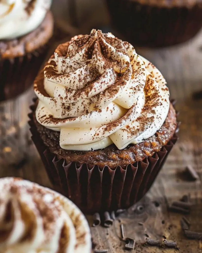 Tiramisu cupcakes soaked in coffee syrup, topped with mascarpone cream and a sprinkle of cocoa powder, showcasing Italian flavored cupcakes and Italian desserts cupcakes.