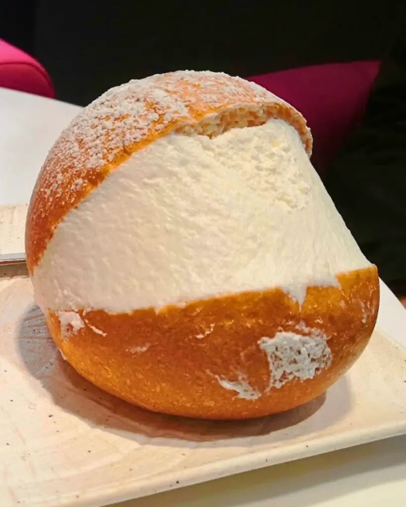 Famous maritozzo from Grué pastry shop in Rome, topped with fresh whipped cream.