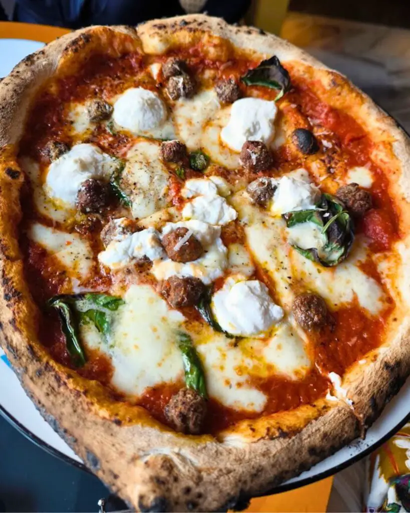 A sumptuous Neapolitan pizza served at Vico Pizza & Wine in Rome, blending traditional flavors with a noble setting.