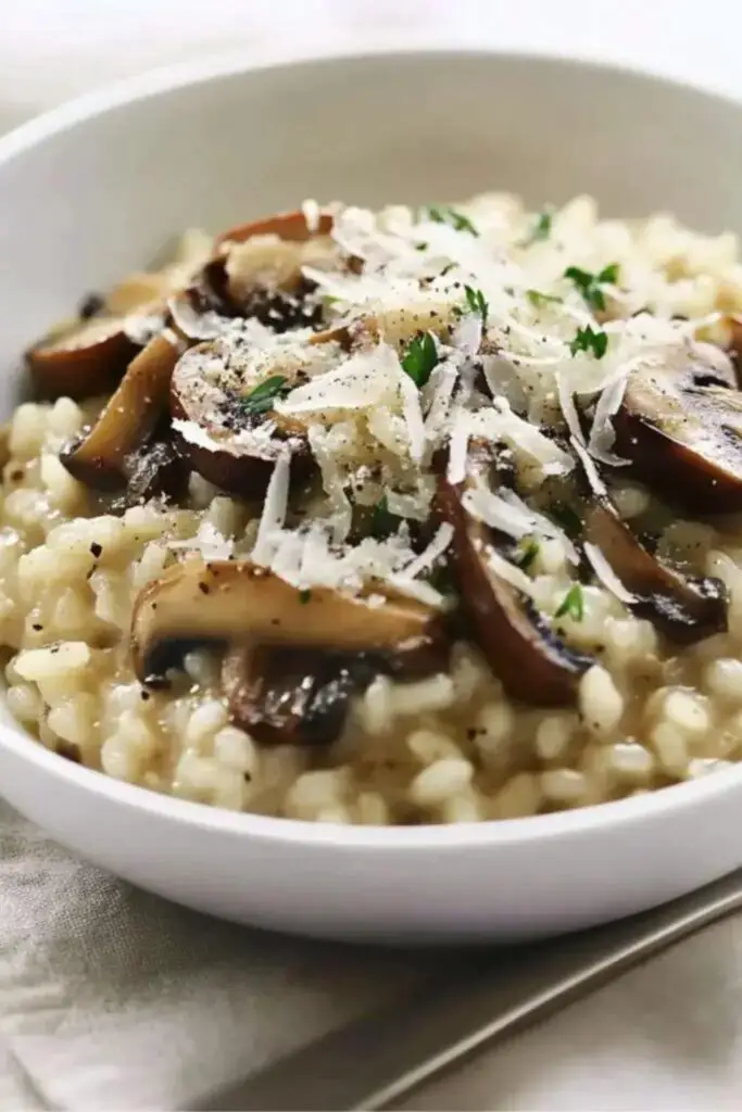 Creamy risotto with porcini mushrooms served in a white bowl, perfect for an Italian-themed Christmas dinner, garnished with fresh herbs and Parmesan.