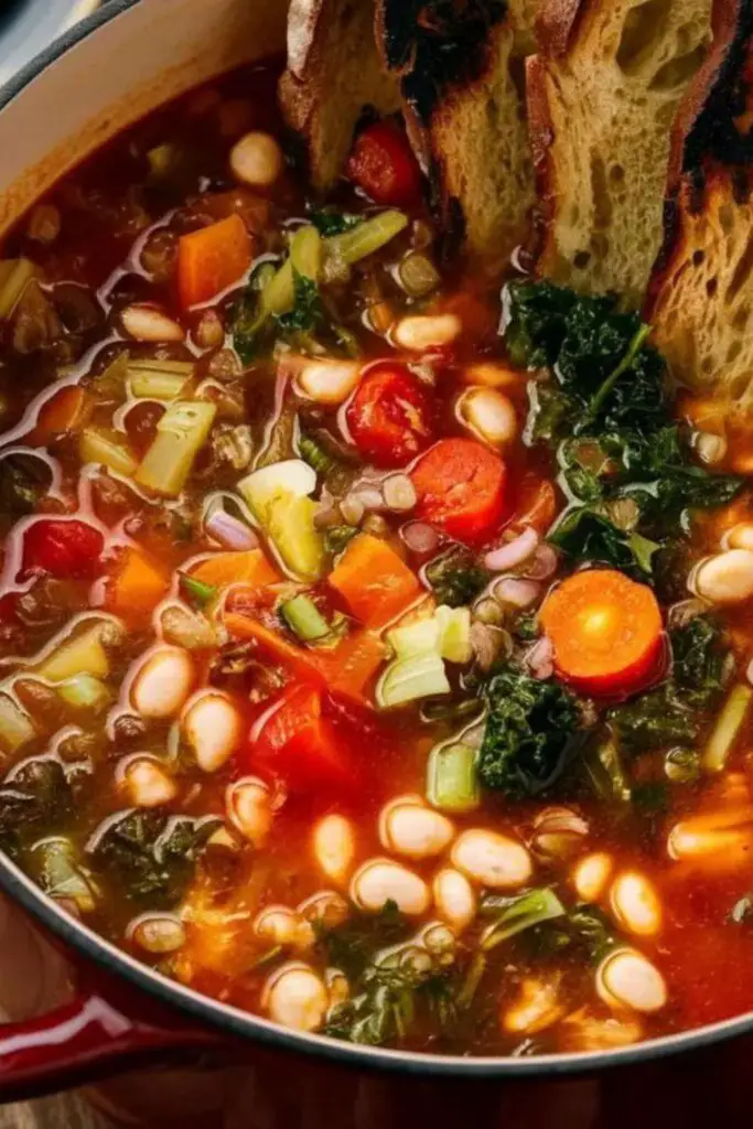 Hearty Ribollita soup with Tuscan vegetables, beans, and slices of toasted bread, served in a rustic black pot, perfect for a cozy Italian-themed Christmas dinner.