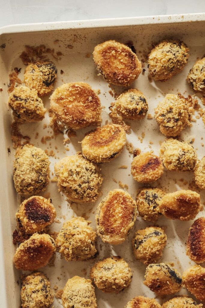 A tray of golden, crispy Brussels sprouts coated in a crunchy Parmesan crust, freshly baked to a delicious crisp. These bite-sized snacks are perfect for a festive Christmas buffet and add a savory touch to any holiday spread.