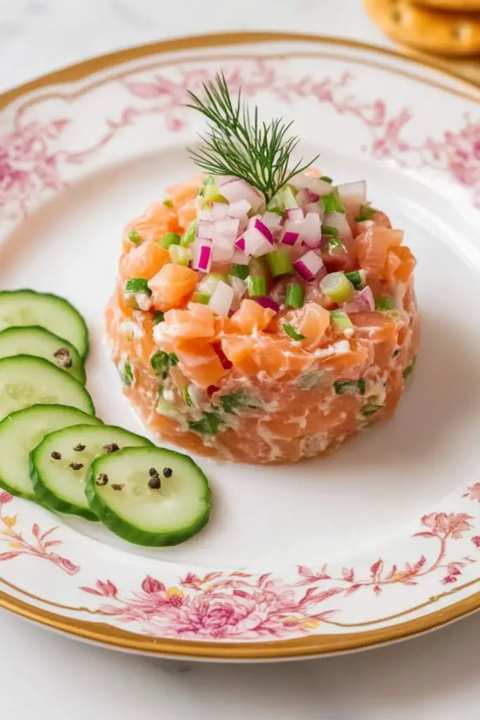 Elegant plate of salmon tartare garnished with capers, pink peppercorns, and herbs, served alongside cucumber slices. Perfect as an appetizer for an Italian Christmas Eve dinner with a focus on light seafood dishes.