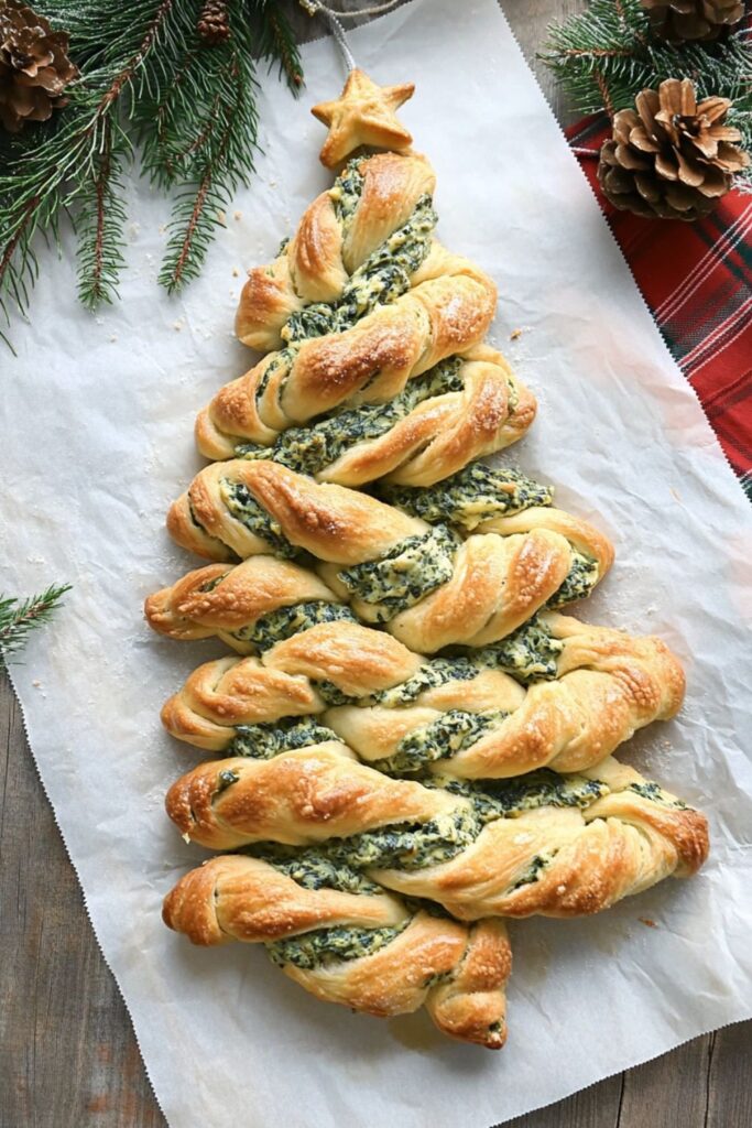 A Christmas tree-shaped spinach dip breadstick arrangement with golden-brown twists, perfect for a festive holiday buffet.