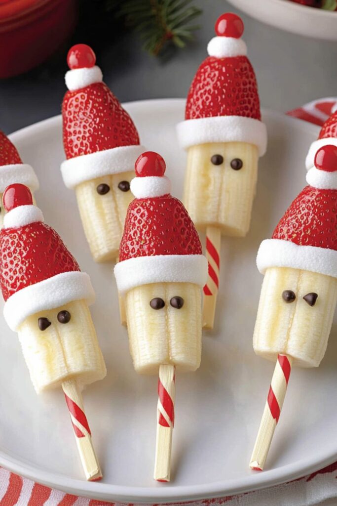 Santa pops made from bananas, strawberries, and marshmallows on a stick, great as a holiday snack for kids.