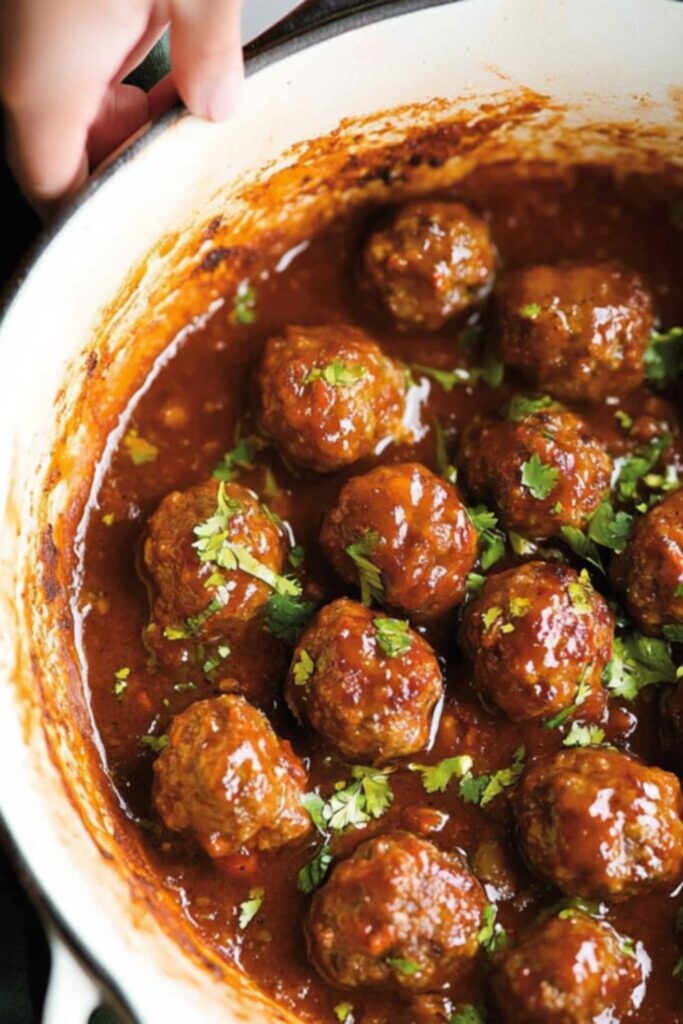 A slow cooker filled with sticky BBQ meatballs coated in a rich and tangy sauce, ideal for game day meatballs crockpot recipes.