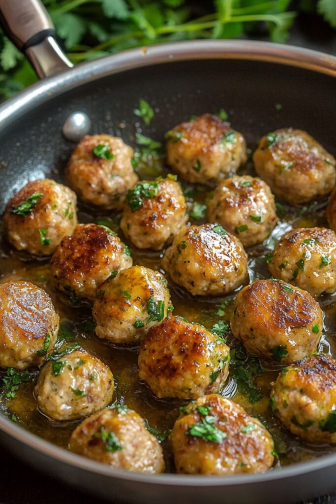 A skillet filled with browned, juicy Italian meatballs garnished with parsley, showcasing a classic recipe for Super Bowl appetizers.