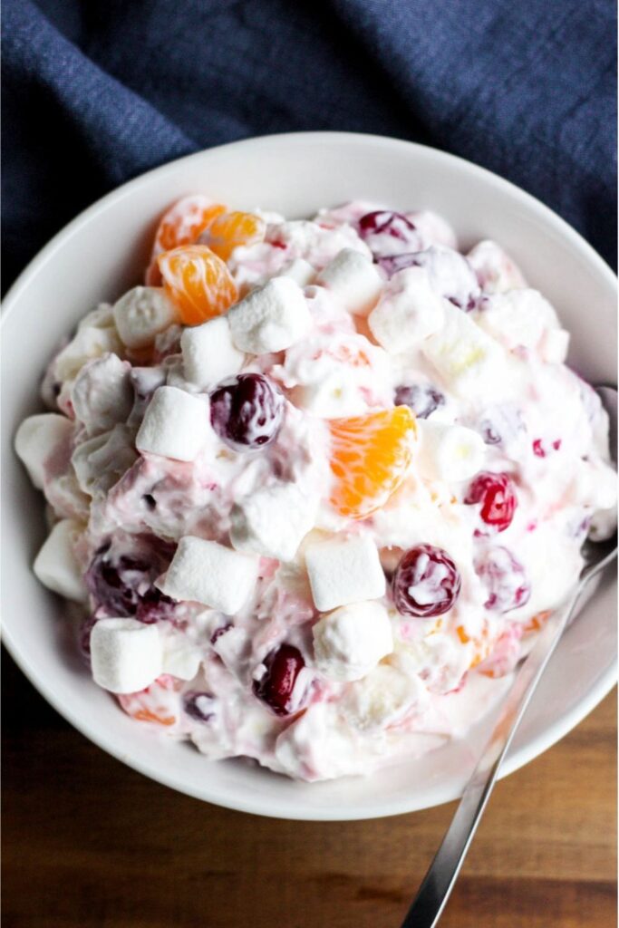 A bowl of colorful ambrosia salad with marshmallows and fruit as one of the July 4th salads.