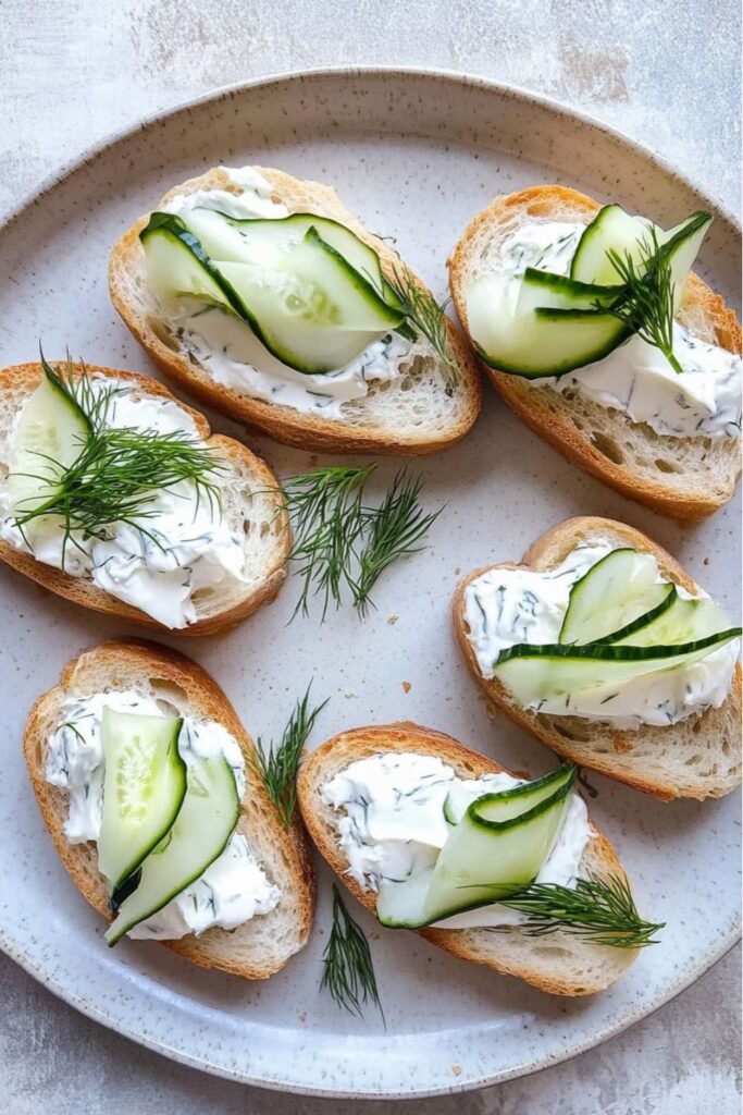 Crispy baguette slices topped with cream cheese and cucumber, a perfect picnic side dishes option.