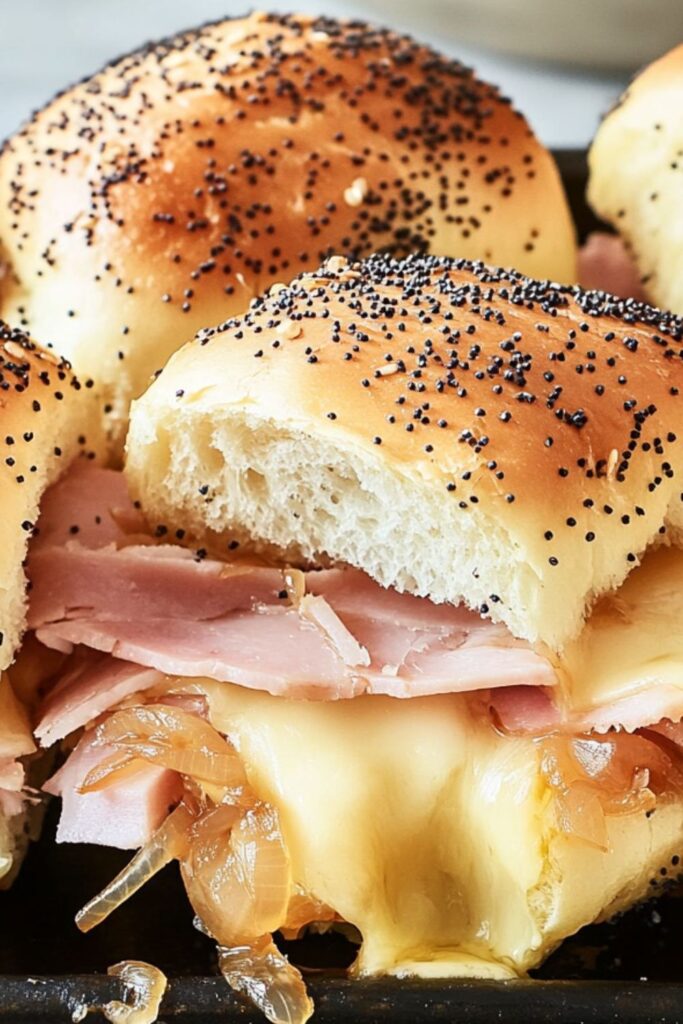Warm ham and swiss sliders with poppy seed tops, a standout example of cookout side dishes.